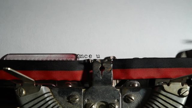 Typewriter vintage writing text "Once upon a time" on white paper close up