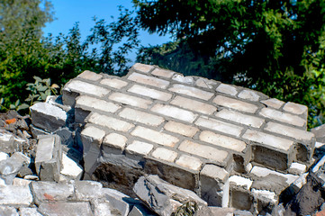 Fragments of a wall of a gray brick at utilization of a brick building