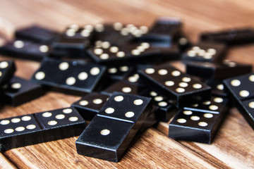 Black old, vintage dominoes on a wooden table closure. The concept of the game dominoes. Selective...