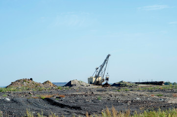 A huge excavator carries rock from the unloaded train from the mine. The concept of mining and environmental problems.