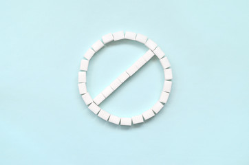 Sign of the ban of sugar cubes on a pastel blue background