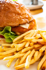 French fries with big burger on the white plate. The most popular fast-food item. Closeup food photo © AtjananC.