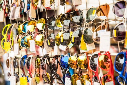 joung beautiful blond woman on the market are looking for some gifs, sunglasses and bags. she is shopping on a sunny day in italy on her travel