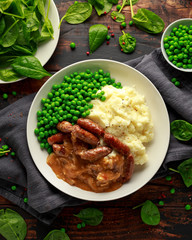 Mashed potatoes and sausages, bangers with onions gravy, green peas