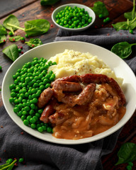 Mashed potatoes and sausages, bangers with onions gravy, green peas