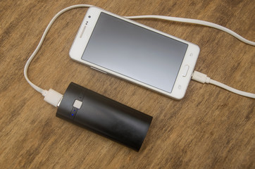 Powerbank and mobile phone on wooden table
