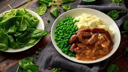 Mashed potatoes and sausages, bangers with onions gravy, green peas
