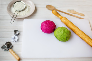 Two kinds of dough on the board. Homemade cooking pasta with spinach and beetroot.