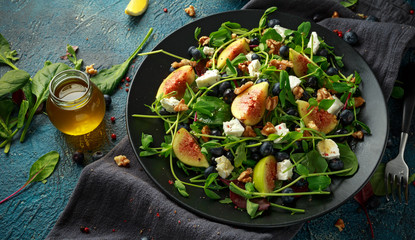 Figs salad with blueberries, walnuts, feta cheese and green vegetables. healthy food