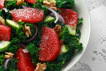 Healthy vegan, vegetarian Grapefruit kale salad with walnuts, red onion and cucumber