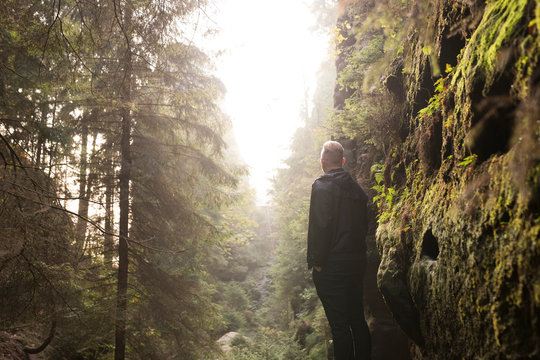 Mann steht auf Felsen im Wald