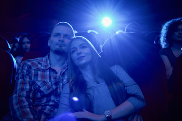 Dark blue effect of couple embracing in cinema.