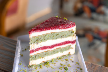 Pistachio and berry cake on white plate