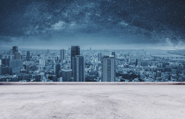 Osaka city skyline, downtown business district at night with empty concrete floor 