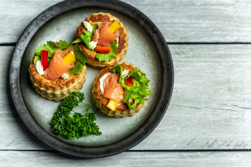 French cuisine, crunchy patties with lettuce and smoked salmon on a bright, rustic background