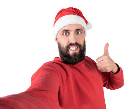 Surprised man in santa headwear gesturing humb up