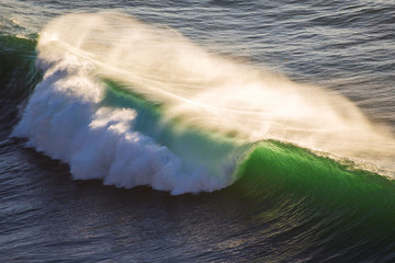 Crashing wave at sunset with strong winds © Bruno