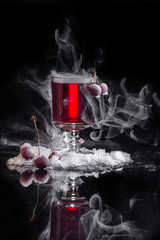 вишневое вино с дымом и замороженной ягодой на снегу
