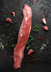Raw pork fillet with herbs and seasoning on stone board