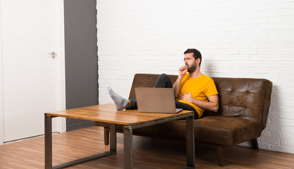 Man with his laptop in a room is suffering with cough and feeling bad
