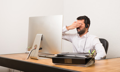 Telemarketer man in a office covering eyes by hands. Do not want to see something