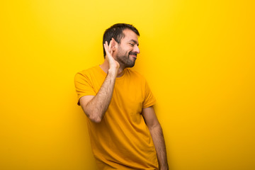 Fototapeta premium Man on isolated vibrant yellow color listening to something by putting hand on the ear