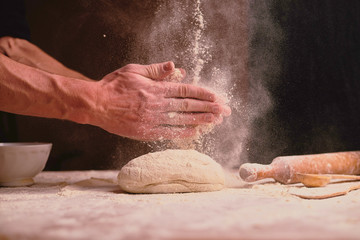 hands kneading dough on table