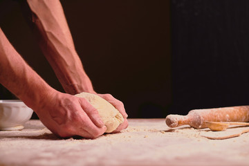 hands of baker kneading dough