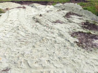 Sand texture on the ground. Car traces. Process of building.