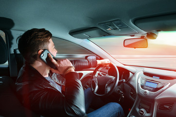 A man talking on a mobile phone in a car at high speed. Driving at high speed. Car travel.