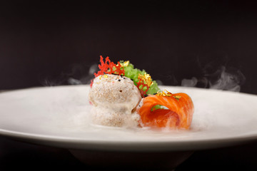 Molecular cuisine gravlax trout with garlic ice cream on a black background