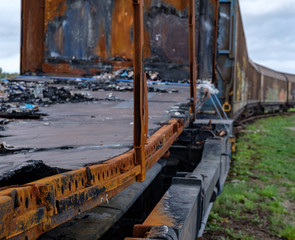 Fototapeta na wymiar burned train car with more wagons out of focus