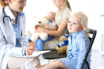 Doctor and a little blonde girl. Usual health exam. Medicine and healthcare concept