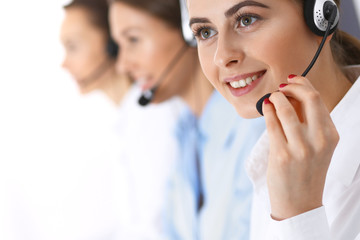 Call center. Group of operators at work. Focus at beautiful business woman in headset