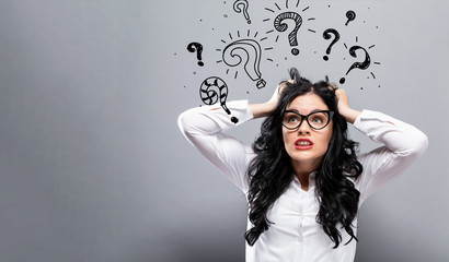 Question marks with young business woman feeling stressed