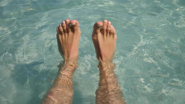 Woman Feet Floating In Turquoise Sea Water On Vacation