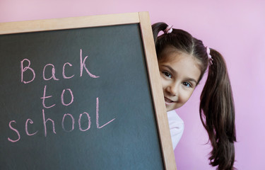 Back to school Happy cute little child girl with  blackboard. 