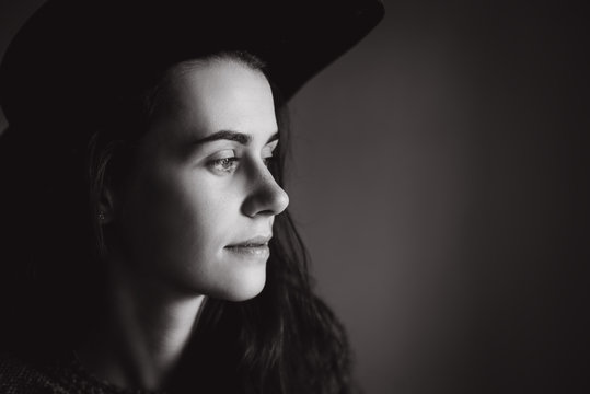 Calm  portrait of beautiful young  woman wearing  black hat . Black and white photo