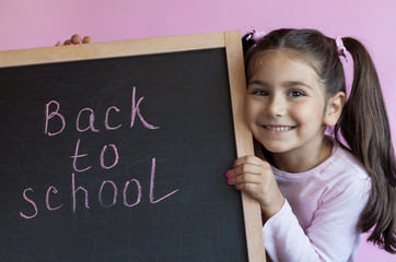 Back to school Happy cute little child girl with  blackboard. 