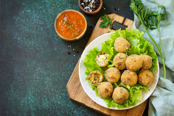 Arancini - traditional Italian Rice Balls with Mozzarella and Sun-dried tomatoes, served with tomato sauce. Copy space.