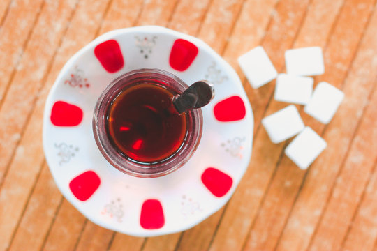 Cup of Turkish tea and sugar lumps on wood table from the top angle at Rize, Turkey