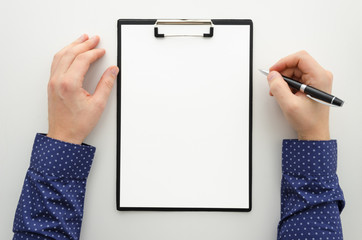 Mock up with blank clipboard with paper document, report ,man holding pen. Businnes office workspace mockup. Flat lay, top view