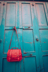 photo of Red girl's hand bag on old weathered metal door in Bethlehem, Palestine