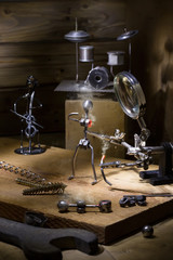 On the old table with night lighting is the assembly of metal chelovechikov. Techno still life.