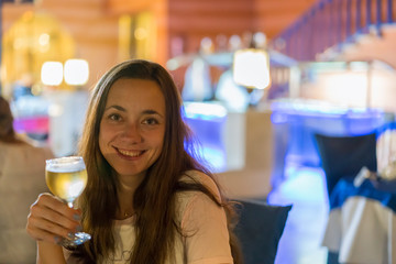 Beautiful young woman with a glass of wine on a blurred background