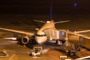 an airplane at night at an airport gate