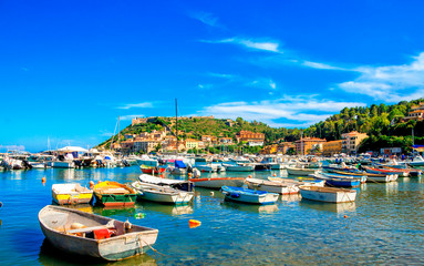 Porto Ercole town,  Monte Argentario, in the Province of Grosseto, Tuscany, Italy. Boats in harbor in a sea bay. - obrazy, fototapety, plakaty