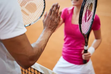 Zelfklevend Fotobehang Two young successful intercultural tennis players giving each other high five over net © pressmaster