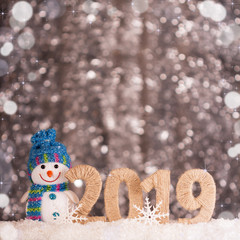 Snowman and new year inscription 2019 with snow background