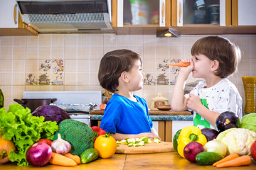 Fototapeta premium Healthy eating. Happy children prepares and eats vegetable salad in kitchen